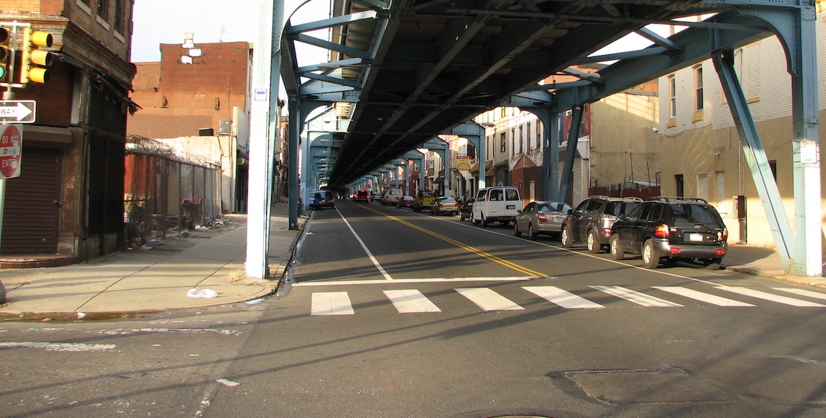 Cars and local businesses line up under the El in Kensington.