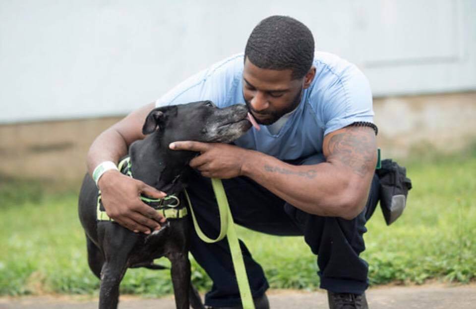 A volunteer with New Leash on Life bonds with a dog that's part of the program.