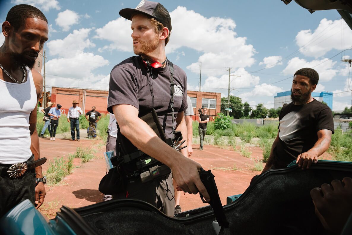 Ricky Staub holds a prop gun alongside OG Law behind the scenes of Concrete Cowboy in North Philadelphia