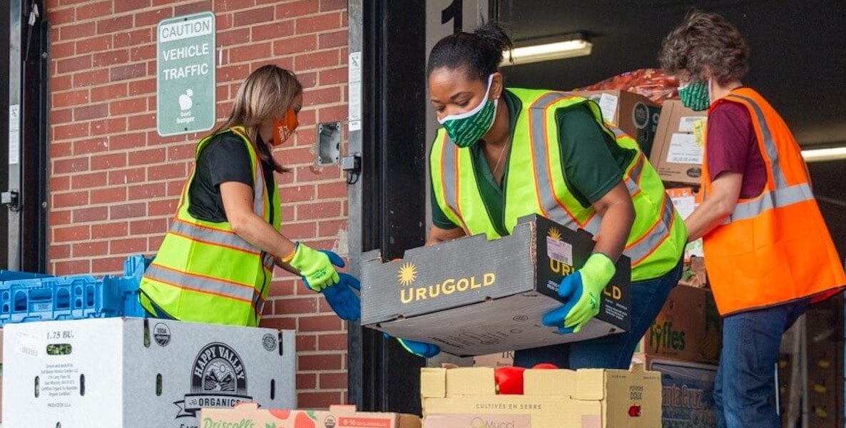 Volunteers load boxes of food that will be donated to people in need during the Covid-19 pandemic