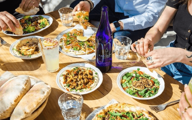 Plates of hummus, manoshe, and other Lebanese / Levantine items fill a table at Suraya in Fishtown, Philadelphia.