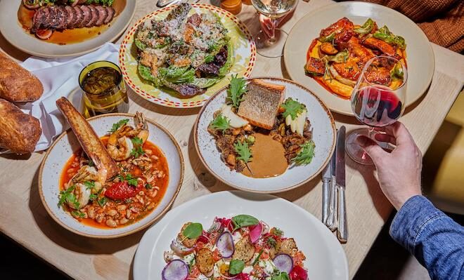 Plates filled with food and drinks fill a table at Talula's Garden.