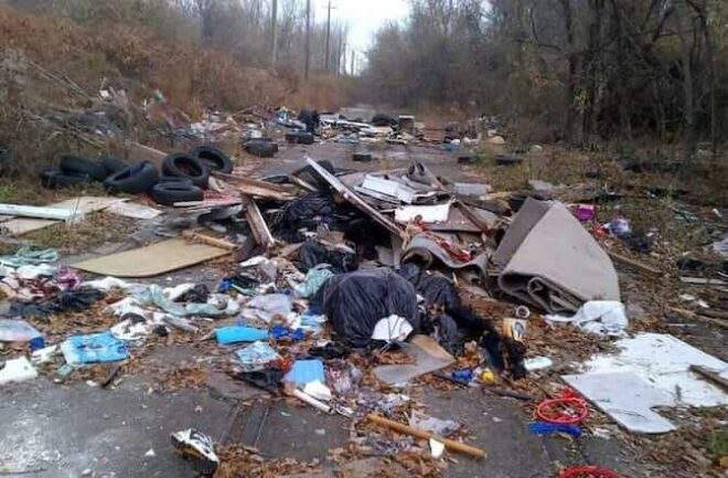 Trash — overflowing bags, carpets, plastic, cardboard — fills a Philadelhpia pathway.