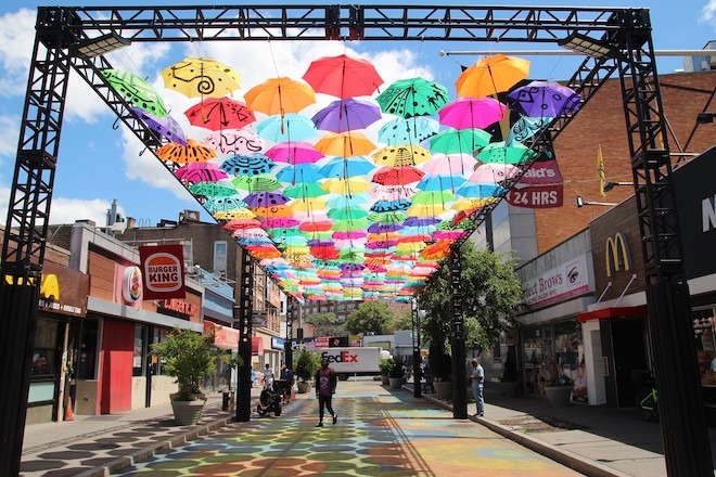 A pedestrian walkway in Brooklyn is part of NYC DOT's Art Arterventions. “Umbrellas” painted by Dennis Darkeem and Naderson Saint-Pierre is installed at Hillel Plaza between Flatbush Avenue and Kenilworth Place, Brooklyn.