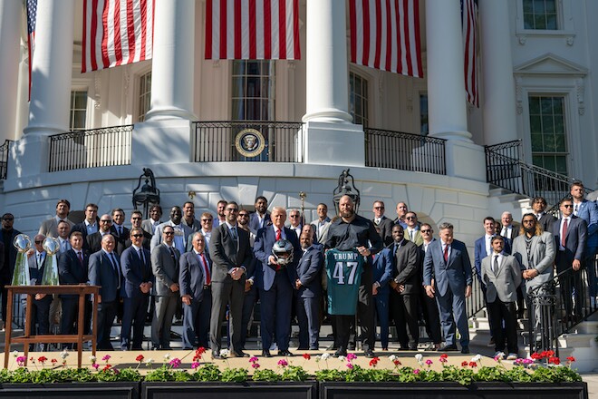 Members of Eagles coaching staff and team pose with President Trump outside the White House.