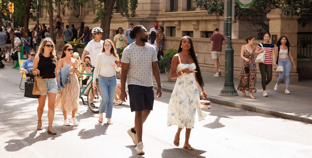 People in summer attire walk along Walnut Street in Philadelphia during Open Streets, when the street closes to vehicular traffic.