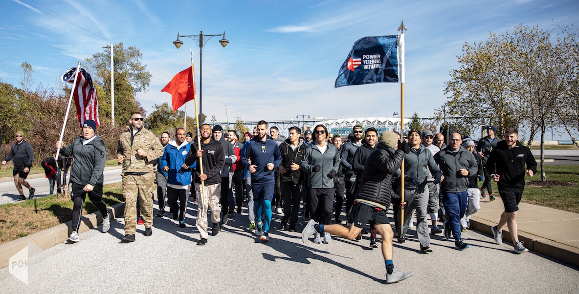 Veteran workers at Power Home Remodeling run together with flags and smiles all around.
