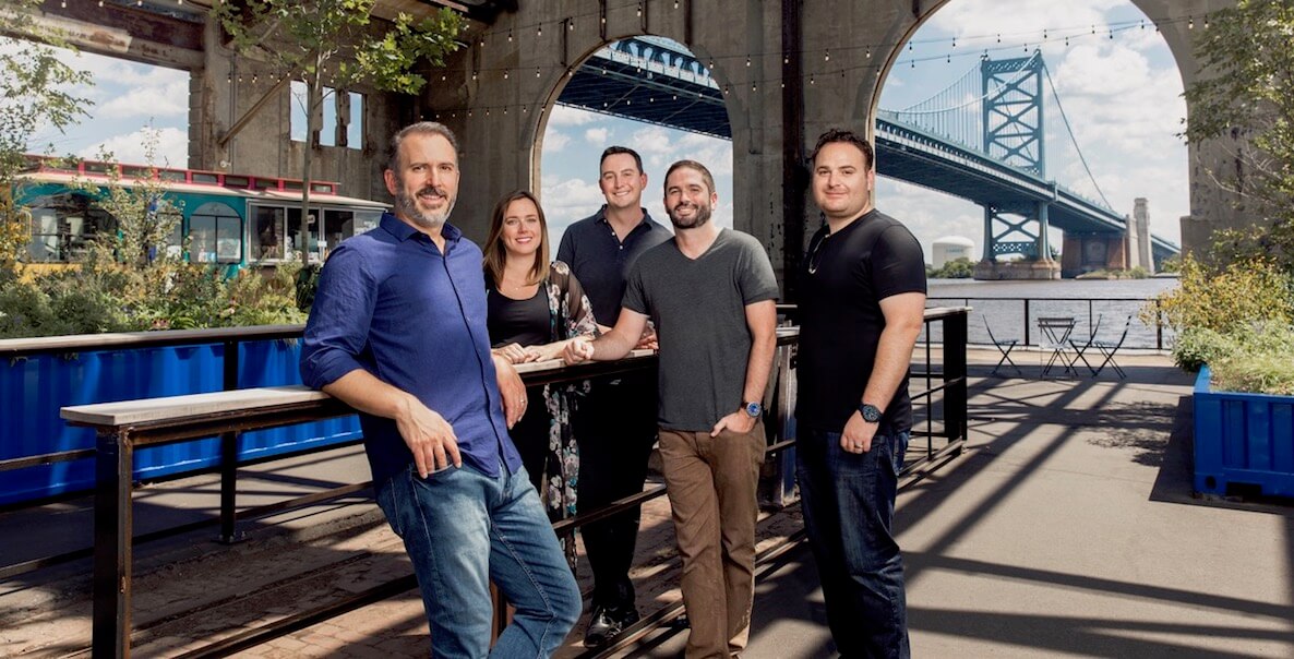 Truth & Consequences staff gathered at Cherry Street Pier with Ben Franklin bridge in the background