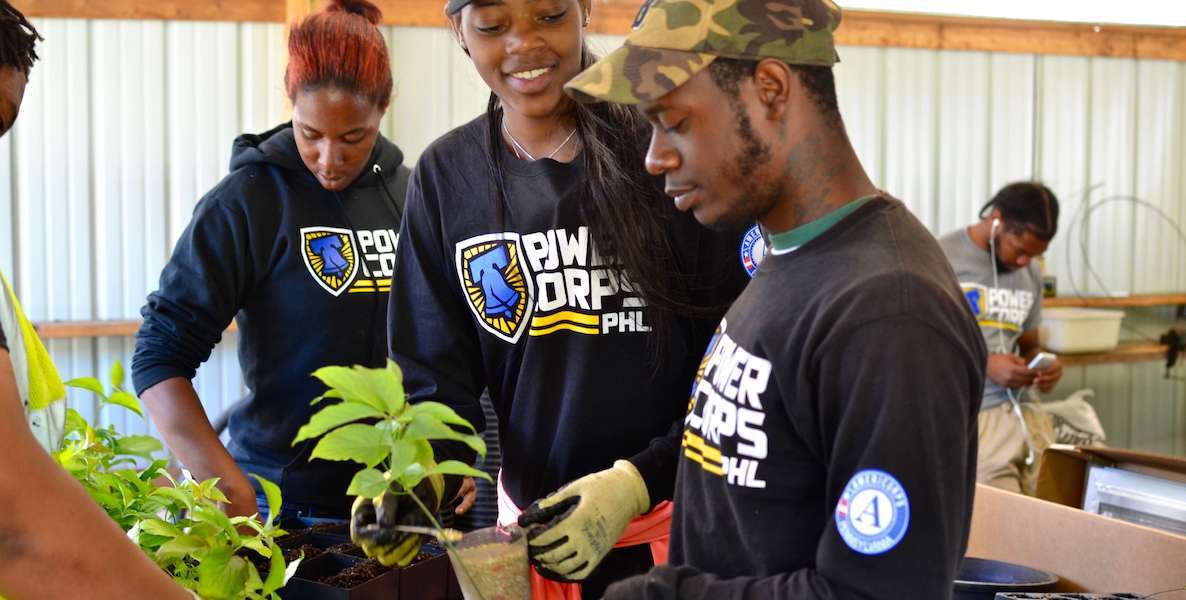 Philadelphia teens get training from PowerCorpsPHL on how to work in a greenhouse with plants.