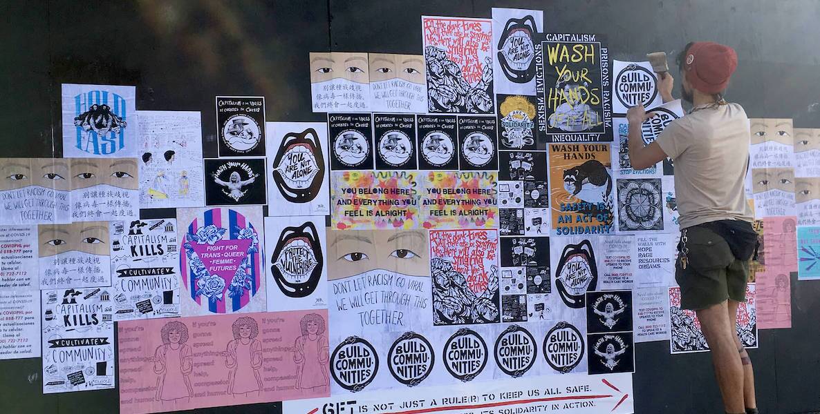 Philadelphia artist-activist Mark Strandquist hangs artwork on a wall in Philadelphia as part of his Fill the Walls With Hope street art campaign.