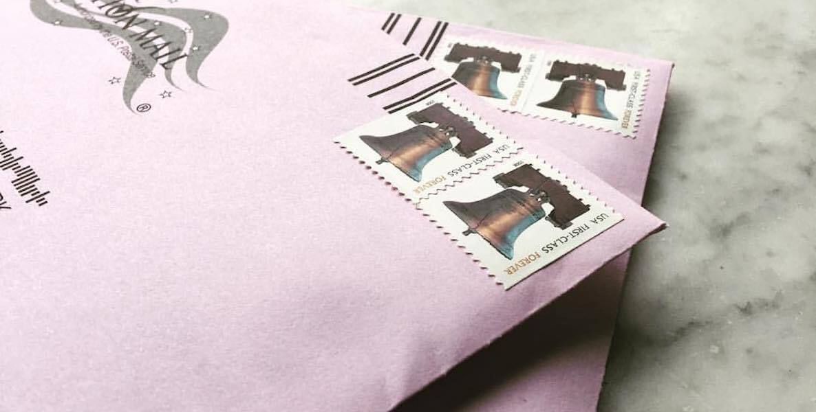 Two envelopes holding mail-in ballots are stamped-up and ready to be put in the mailbox