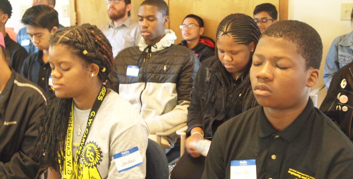 Students of color meditating in classroom
