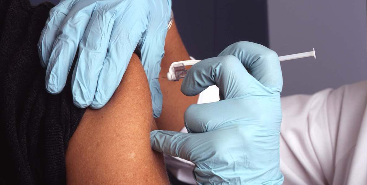 A health official administers a Covid vaccine to a willing participant