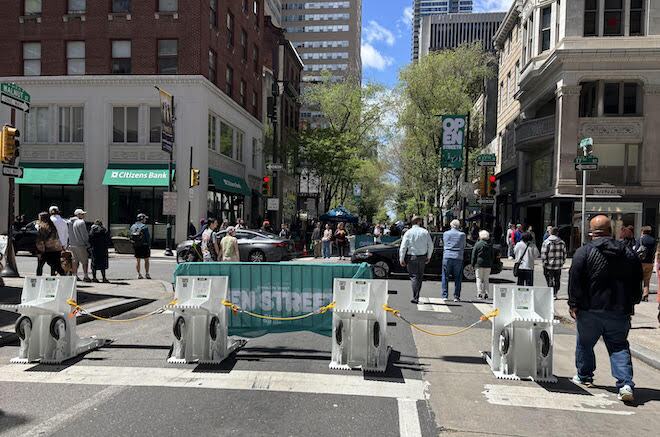 White Meridian-brand barriers connected by yellow cords block off traffic along 17th Street in Philadelphia.