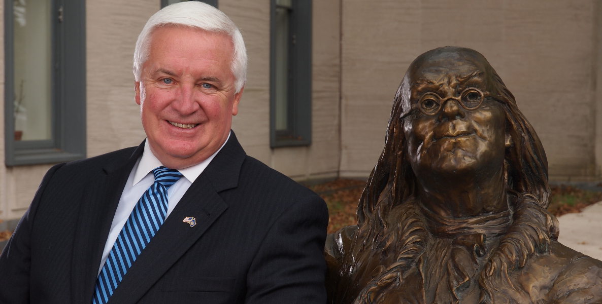 Former Pennsylvania Governor Tom Corbett next to a bust of Ben Franklin