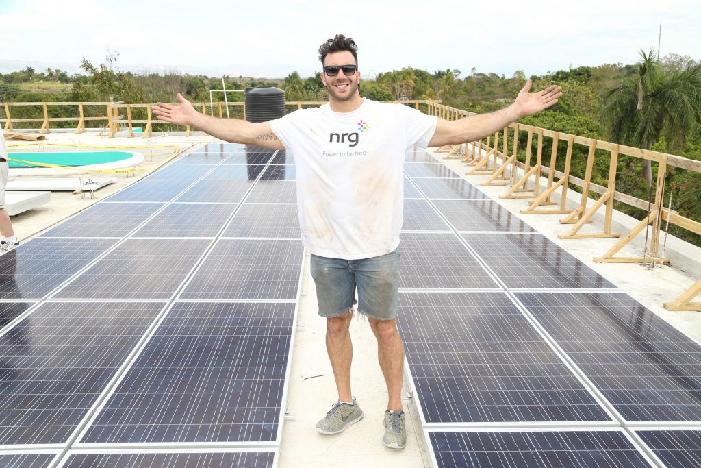 Barwin in Haiti, with solar panels he helped to install. Photo: Omar Vega of Vega Creative Group