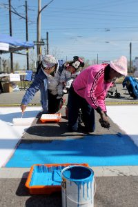 Neighbors paint a crosswalk at the Mantua Greenway Community Build Day