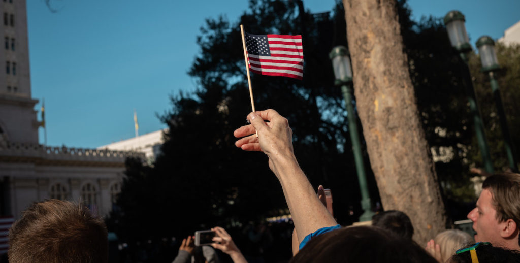 A citizen waves an American flag in the air.