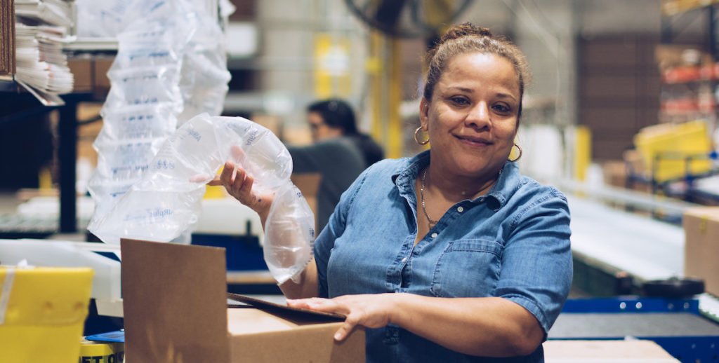An employee of First Step Staffing unpacks boxes in a factory