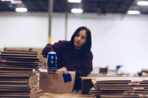 A First Step Staffing employee tapes up boxes at her factory job.