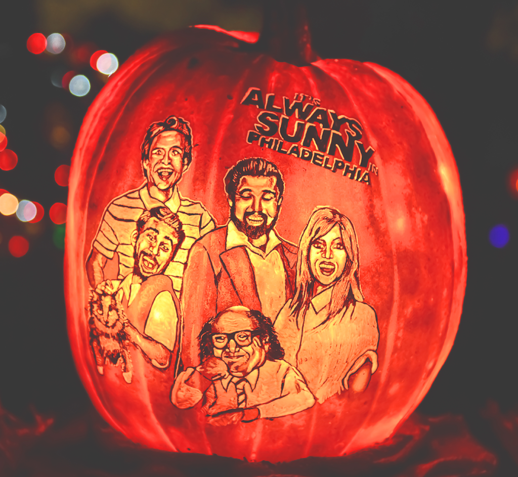 The cast of It's Always Sunny in Philadelphia is carved into a glowing jack-o-lantern