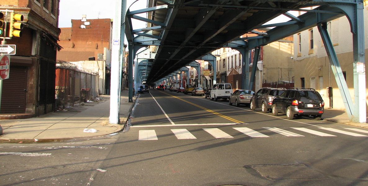 Cars and local businesses line up under the El in Kensington.