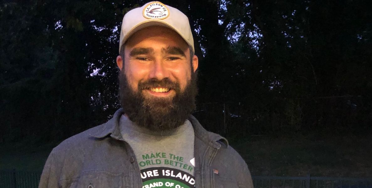 Jason Kelce, wearing a cap and a Make the World Better Foundation T-shirt, smiles into the camera.