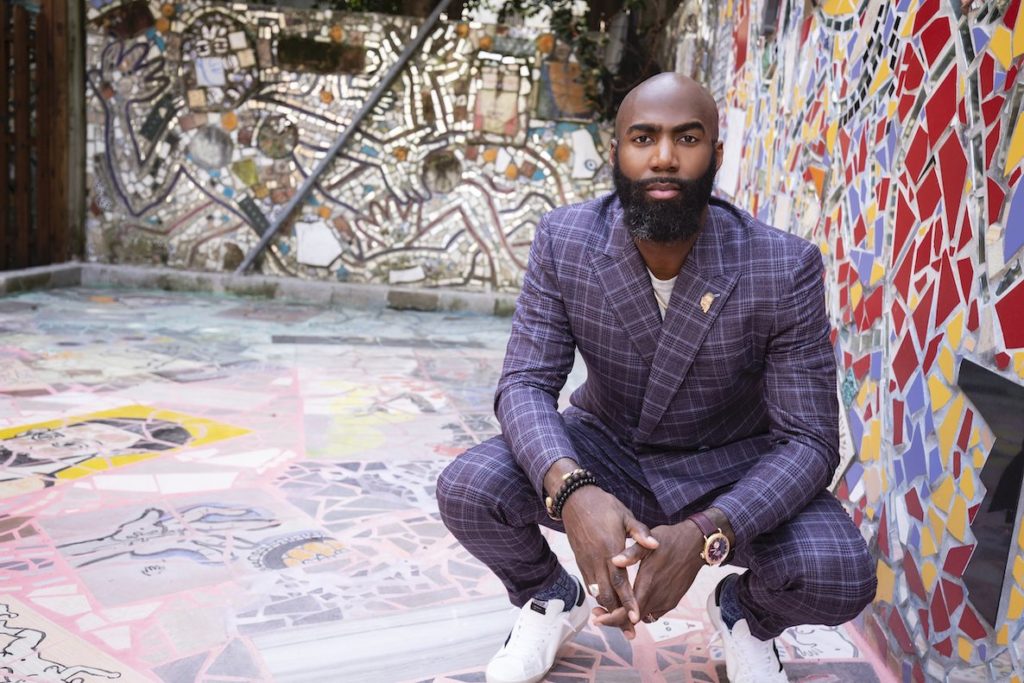 Eagles safety Malcolm Jenkins models one of his form-fitting suits next to a glass mural in South Philly