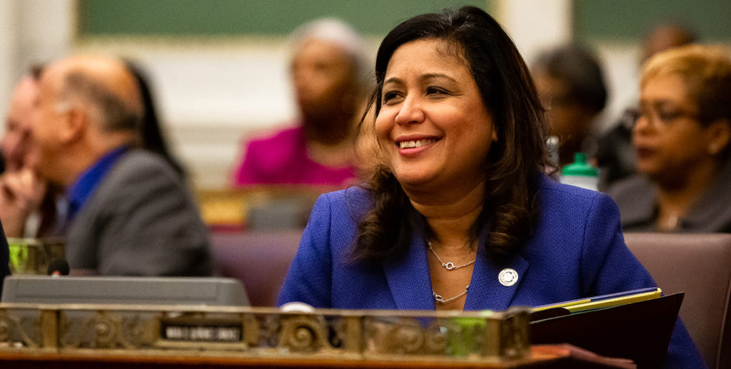 Councilwoman Maria Quiñones-Sánchez smiles from behind her desk in the chamber of Philadelphia City Council