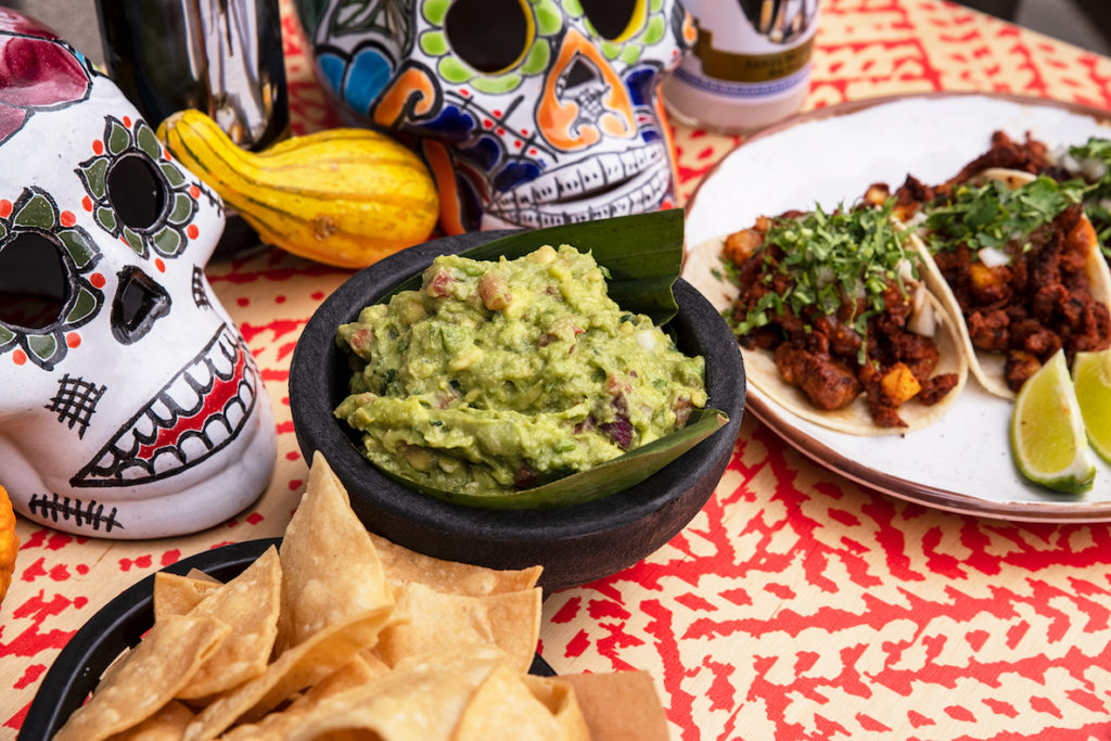 A big bowl of guacamole sits on a table for Rosy's Taco Bar's Dia de los Muertos Festival.