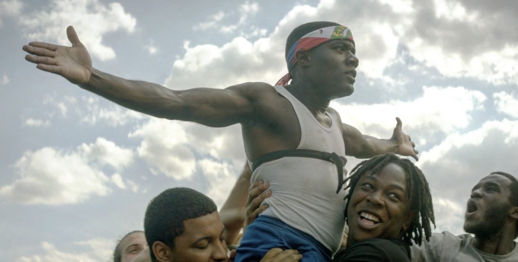A scene from The Nomads, which finds a man wearing a headband with his arms stretched to each side.