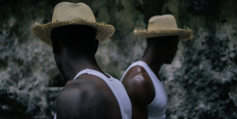 A photograph by artist Melissa Alcena shows a black man in a wife beater and straw hat. It's part of the FON: Women Photographers of the African Diaspora exhibit at the African American Museum in Philadelphia.