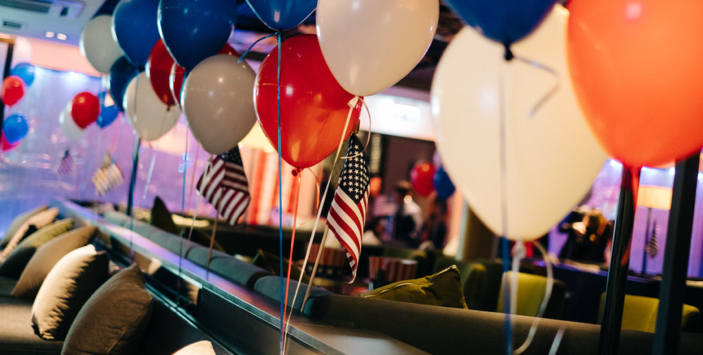 An office celebrates election day with balloons and flags.