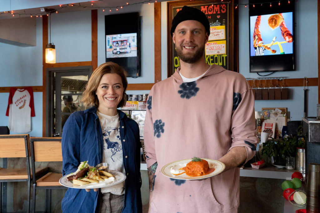 Mom-Mom's Kitchen owners Kaitlin Wines and Ryan Elmore hold plates of Polish food at their South Street restaurant
