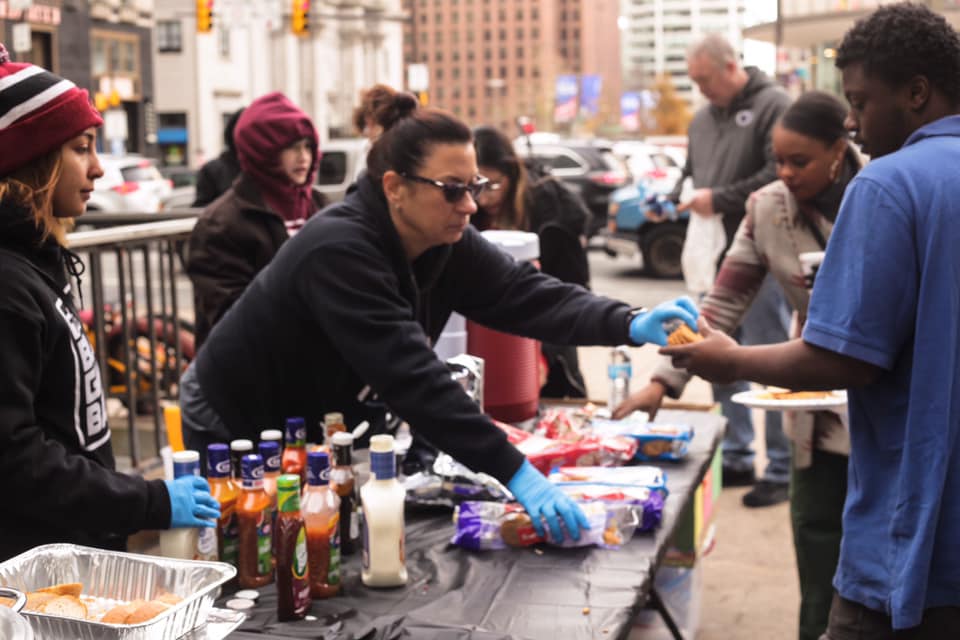 Volunteers with The Block Gives Back serve food to Philadelphians in need.
