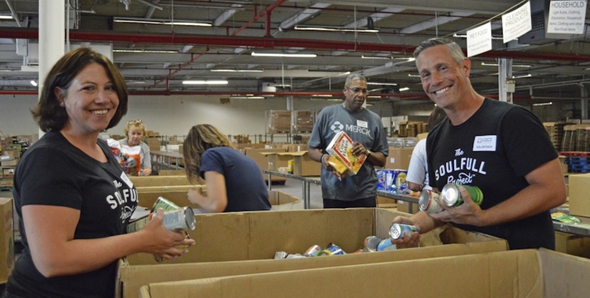 Megan Shea and Chip Heim of The Soulfull Project unload boxes at a food bank.