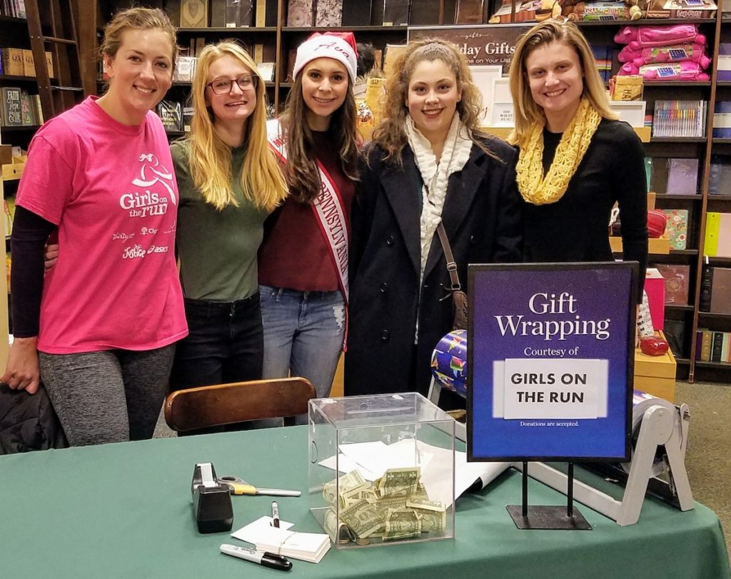 Volunteers pose for a photo at the gift-wrapping table hosted by Girls On the Run Philly