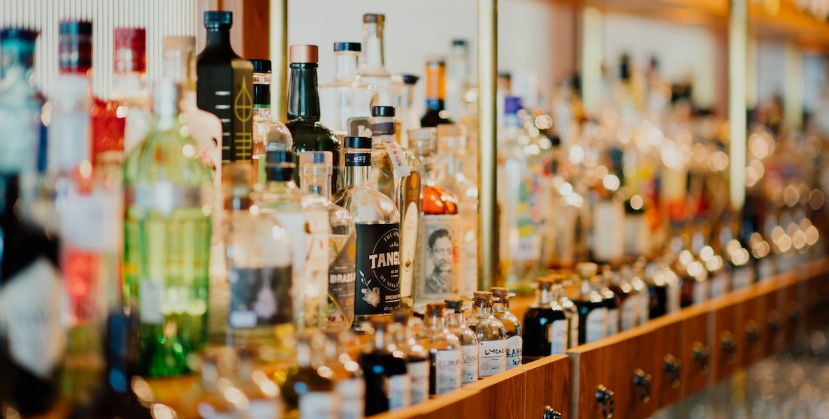 Bottles of liquor line the shelves in a bar
