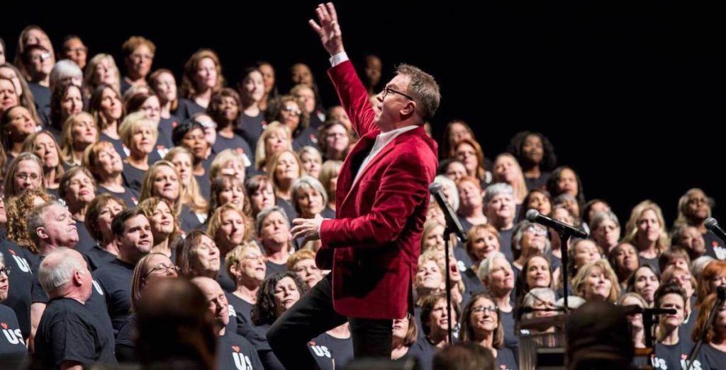 A man in a red blazer conducts a Harmony Project concert in Columbus, Ohio