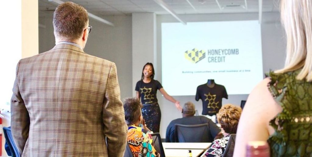 A small business owner working with Honeycomb Credit presents her business idea to a room of investors.