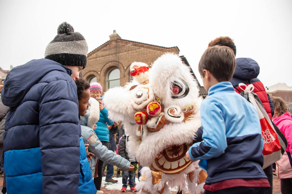 Kids look on as a lion comes there way during the Penn Museum's Lunar New Year festival and lion dance parade. 