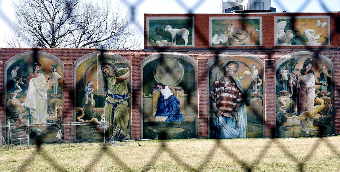 A mural in Philadelphia blurred by a steel fence.