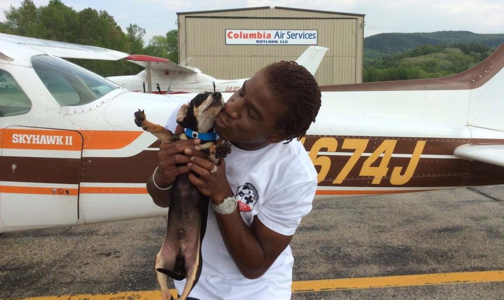 A man kisses his new dog that he got from nonprofit group Pilots to the Rescue