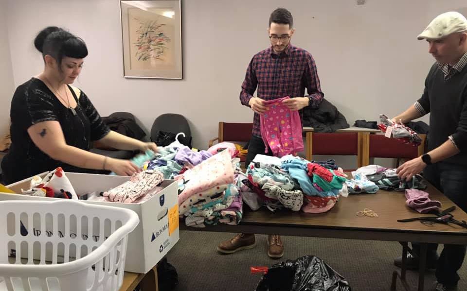 Volunteers help organize clothing at Turning Points for Children
