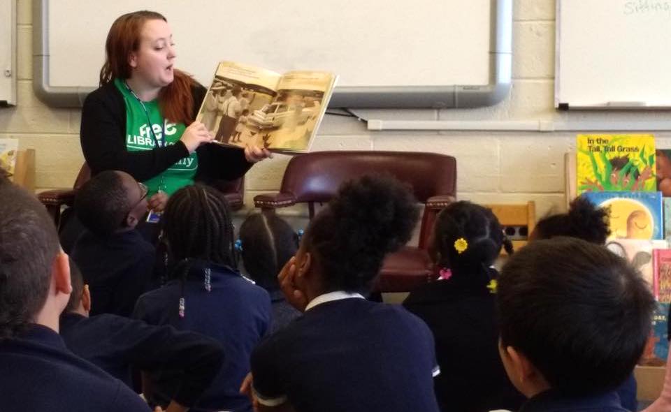 A WePAC volunteer reads to a roomful of children. 