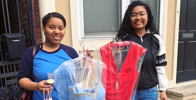Two girls show off gowns that they got from Philly Phairytale, a nonprofit that donates prom dresses to girls in need. 