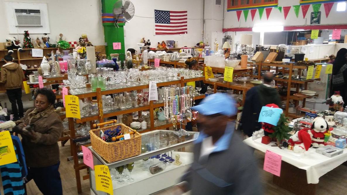 Customers and volunteers organize goods at the Second Mile Center in Philadelphia