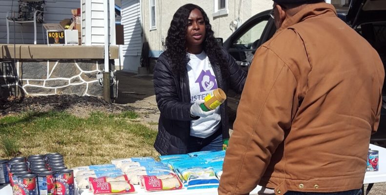 Community College of Philadelphia staff member Pisetta Arrington gives free food to a man during the coronavirus pandemic in Philadelphia.