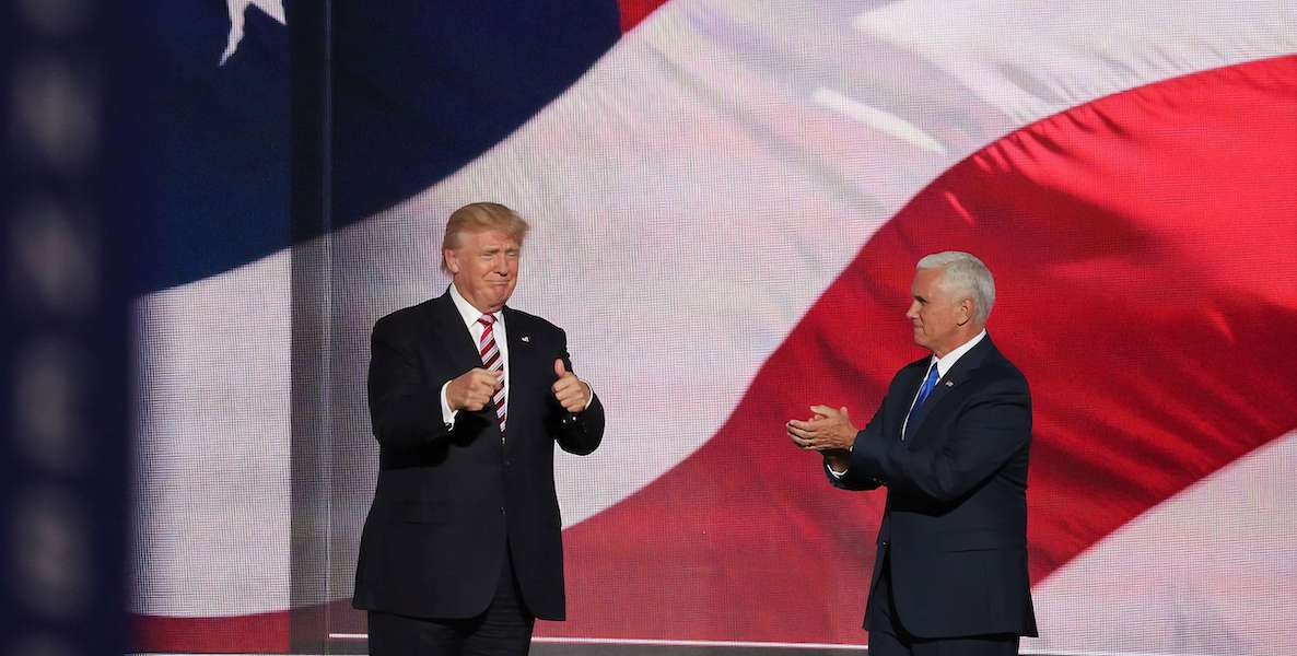 Donald Trump give thumbs up and applaud each other in front of an American flag.