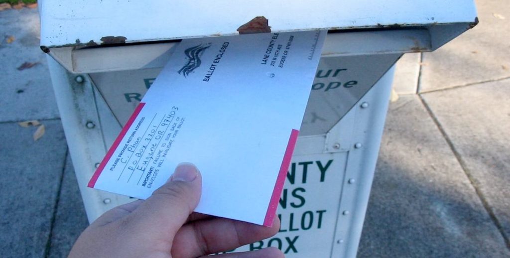 A voter drops his mail-in ballot in a mailbox. Letting residents in PA vote by mail could save the election from low turnout due to the coronavirus.